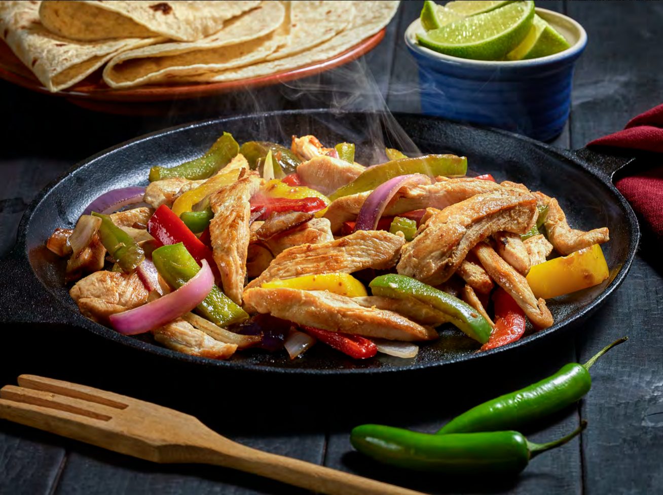 Chicken fajitas with peppers in a skillet
