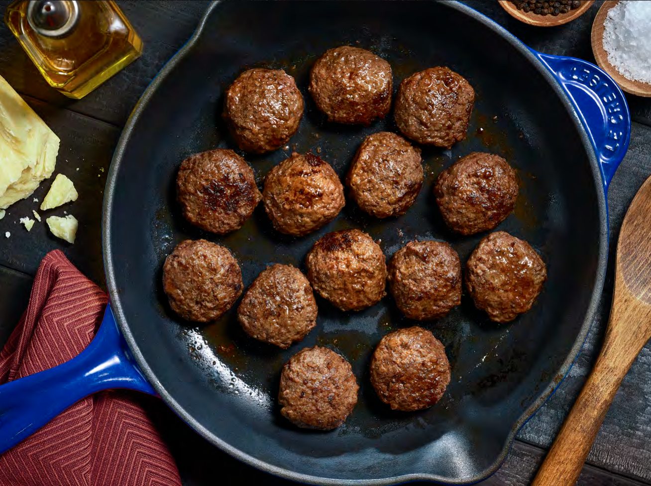 Meatballs browning in a cast iron pan